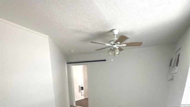 interior details featuring ceiling fan, a textured ceiling, and heating unit