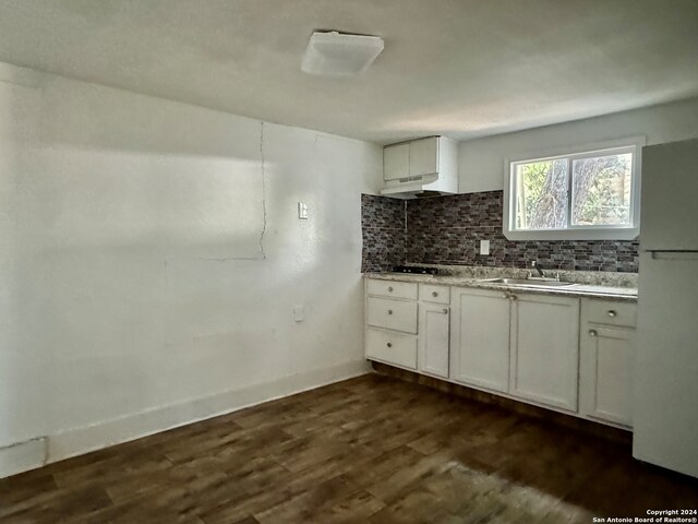 kitchen featuring dark wood-type flooring, sink, white cabinetry, white fridge, and backsplash