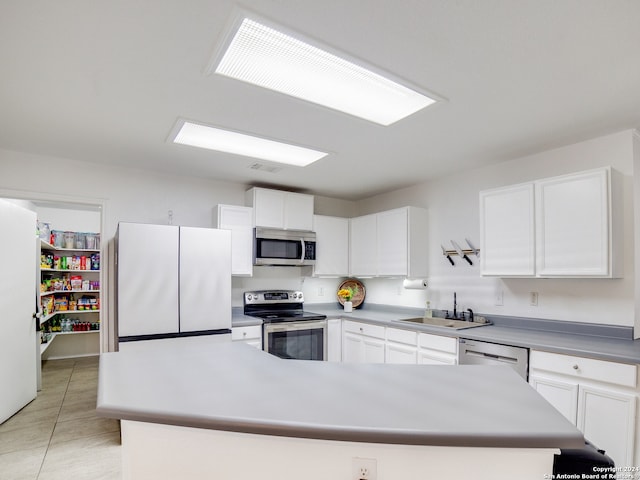 kitchen with white cabinetry, light tile patterned floors, stainless steel appliances, a center island, and sink