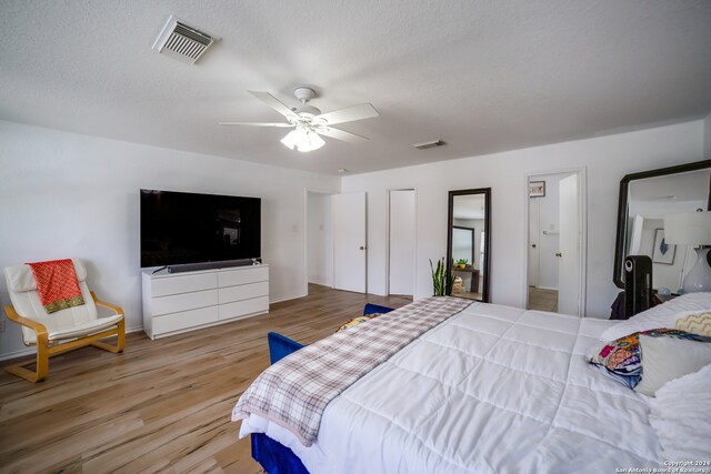 bedroom with ceiling fan, hardwood / wood-style flooring, and a textured ceiling