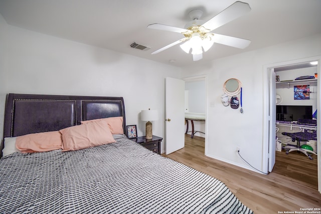 bedroom with light wood-type flooring, ceiling fan, and a closet