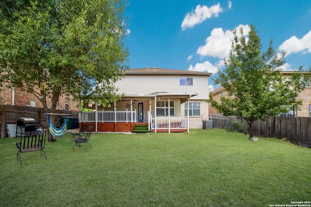 rear view of house featuring a lawn and central air condition unit