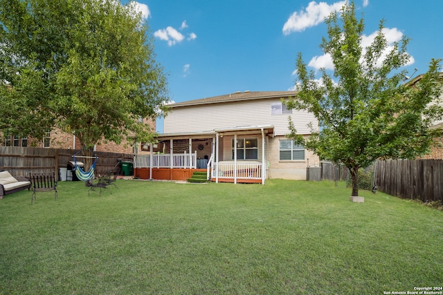 back of property with a lawn, central AC, and a deck