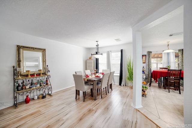 dining room featuring a textured ceiling and light wood-type flooring