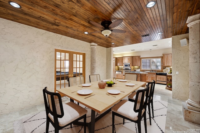 dining room featuring ceiling fan, french doors, decorative columns, and wooden ceiling