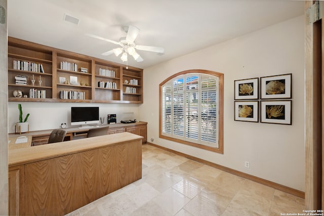 home office with built in desk and ceiling fan