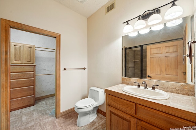 bathroom with walk in shower, vanity, and toilet