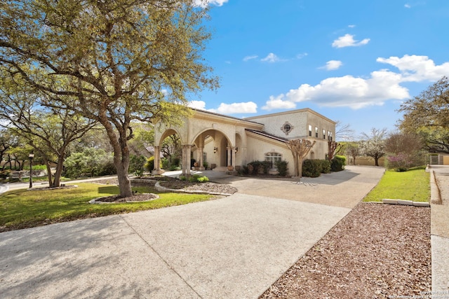 mediterranean / spanish-style home with a front yard