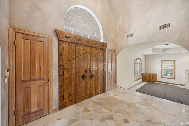 tiled foyer featuring a high ceiling