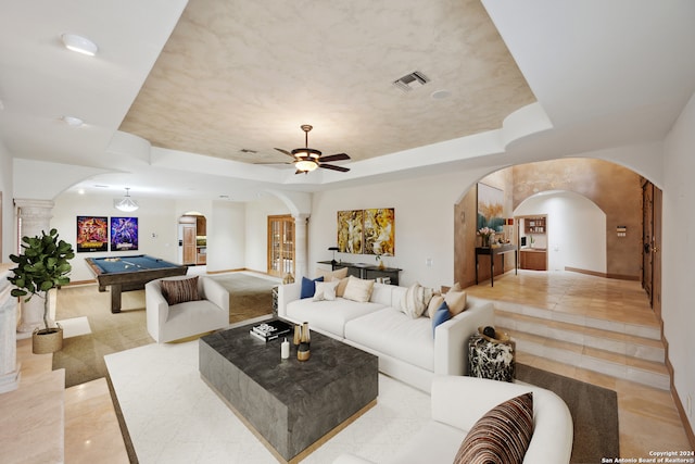 living room featuring ceiling fan and a tray ceiling