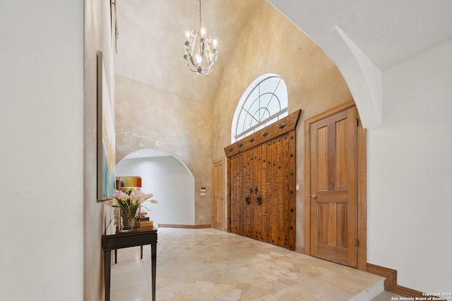 entrance foyer featuring high vaulted ceiling and a chandelier