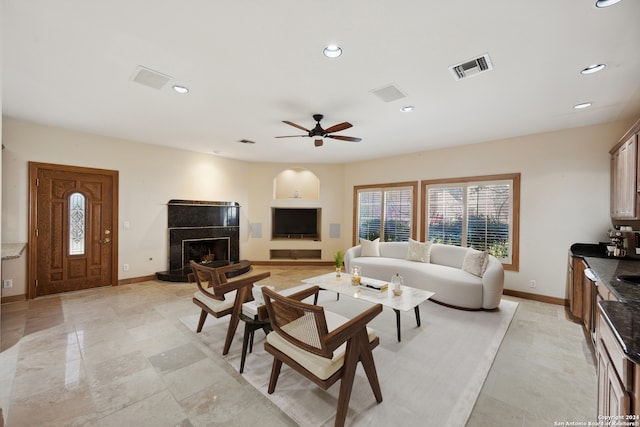 living room with ceiling fan and a fireplace