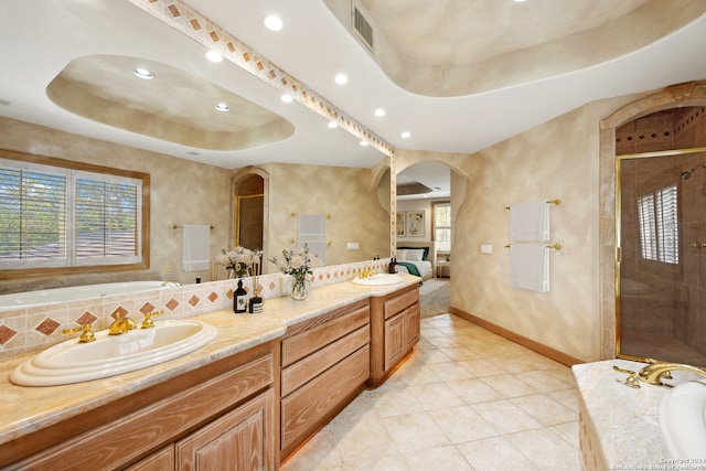 bathroom with shower with separate bathtub, vanity, tile patterned floors, and a raised ceiling