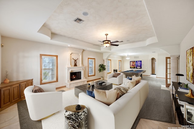 living room featuring ceiling fan, a tray ceiling, and pool table