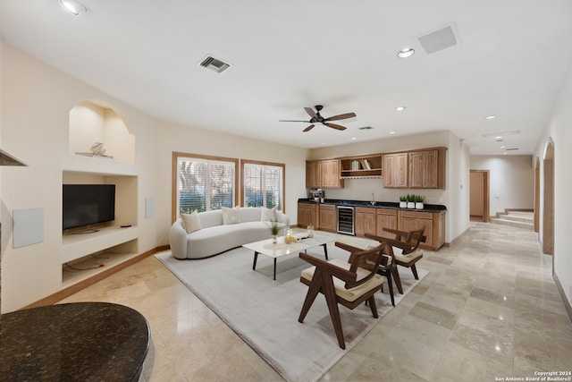 living room featuring wine cooler, ceiling fan, and sink