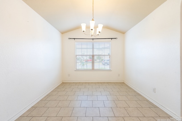 tiled spare room featuring an inviting chandelier and lofted ceiling