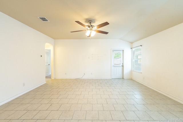 empty room featuring lofted ceiling, ceiling fan, and light tile patterned floors