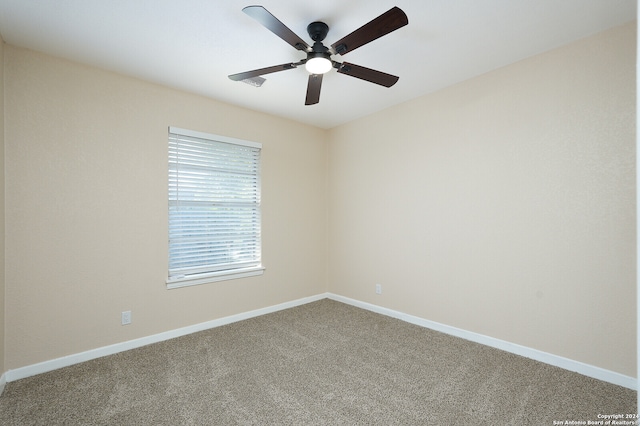 carpeted spare room featuring ceiling fan