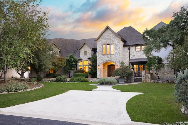 french country inspired facade featuring a lawn