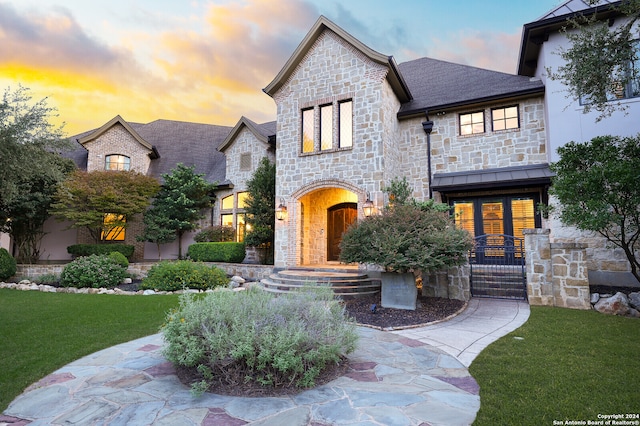 french country inspired facade featuring a lawn