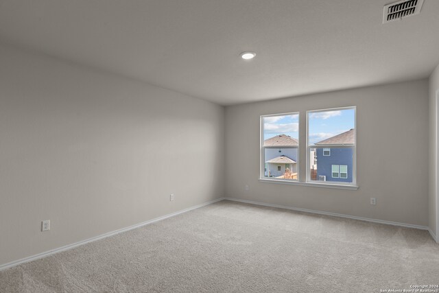 unfurnished room featuring light carpet