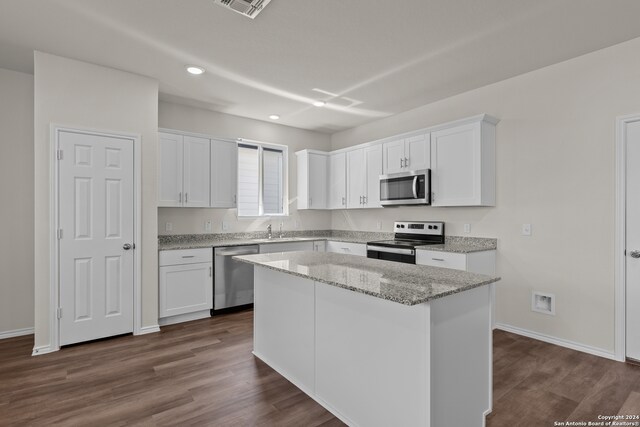 kitchen featuring appliances with stainless steel finishes, a center island, dark hardwood / wood-style flooring, and white cabinets