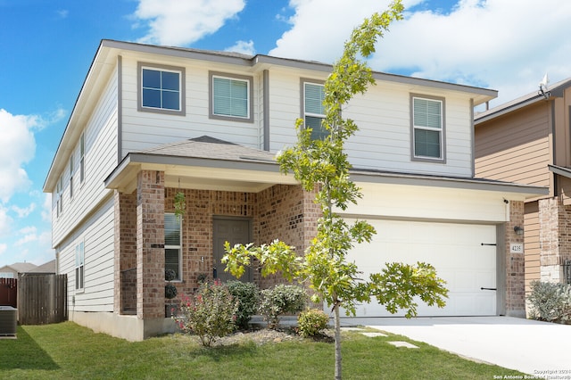 view of front of house featuring a front yard, central air condition unit, and a garage