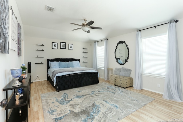 bedroom featuring multiple windows, hardwood / wood-style floors, and ceiling fan