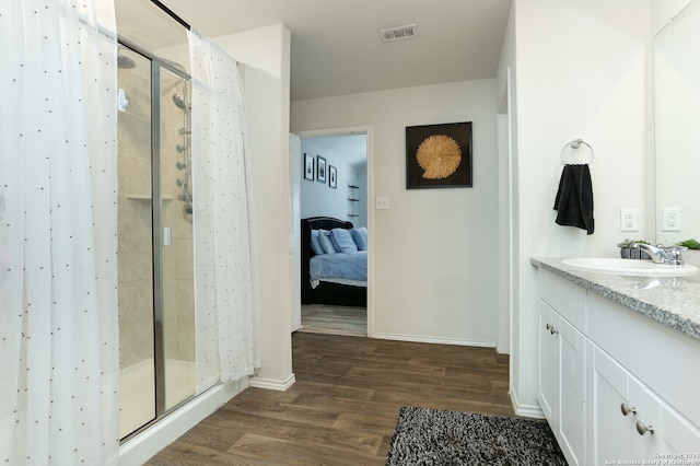 bathroom featuring hardwood / wood-style floors, a shower with door, and vanity