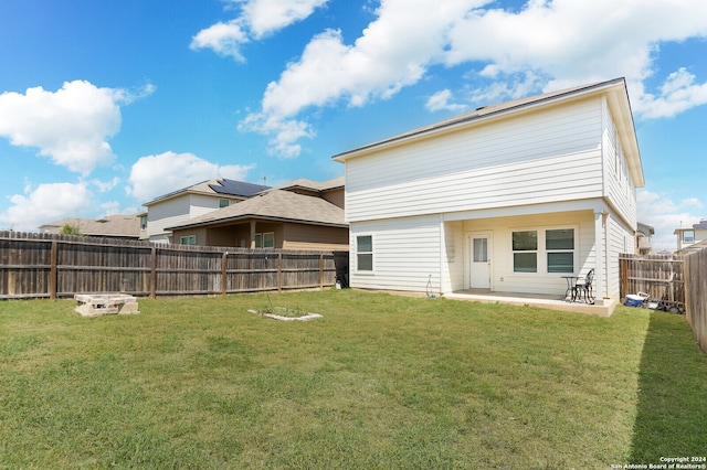 back of property with a yard and a patio area