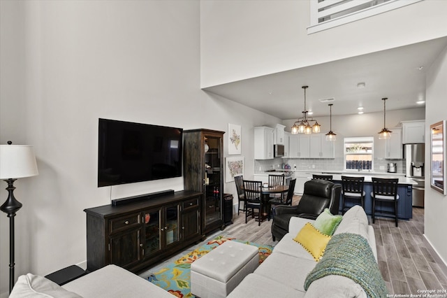 living room with a notable chandelier and light hardwood / wood-style floors