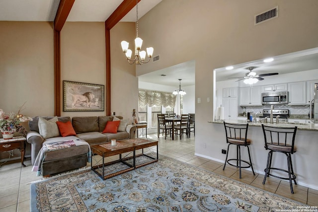 tiled living room with ceiling fan with notable chandelier, beam ceiling, and high vaulted ceiling