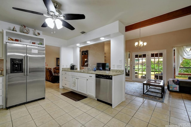 kitchen featuring white cabinets, hanging light fixtures, light tile patterned floors, appliances with stainless steel finishes, and ceiling fan with notable chandelier