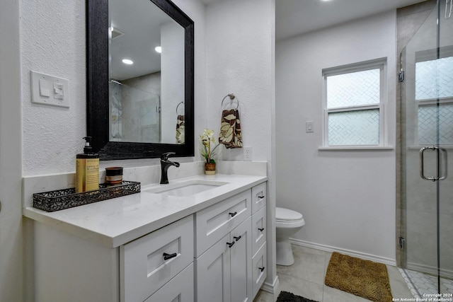 bathroom with tile patterned flooring, vanity, toilet, and a shower with shower door