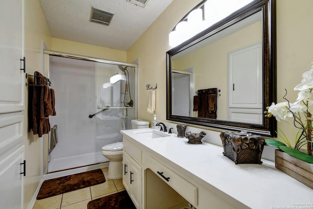 bathroom featuring vanity, walk in shower, a textured ceiling, tile patterned flooring, and toilet