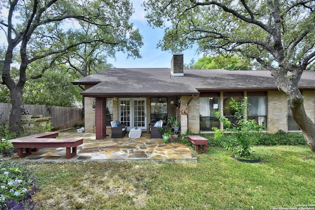 back of property with a lawn and a patio area