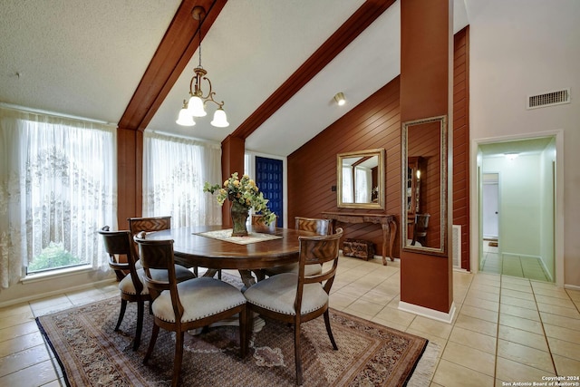 dining space with a healthy amount of sunlight, wooden walls, and a notable chandelier