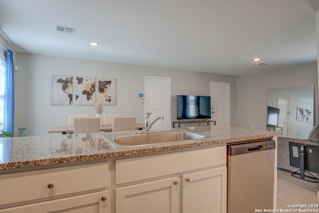 kitchen with dishwasher, light hardwood / wood-style floors, sink, white cabinetry, and light stone countertops