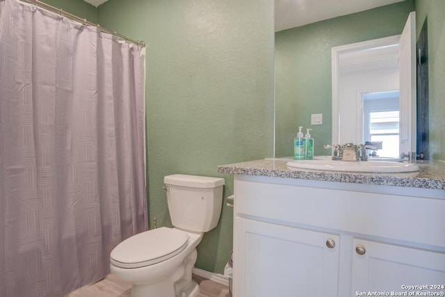 bathroom with walk in shower, vanity, and toilet