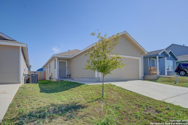 ranch-style home with a front yard, a garage, and central air condition unit