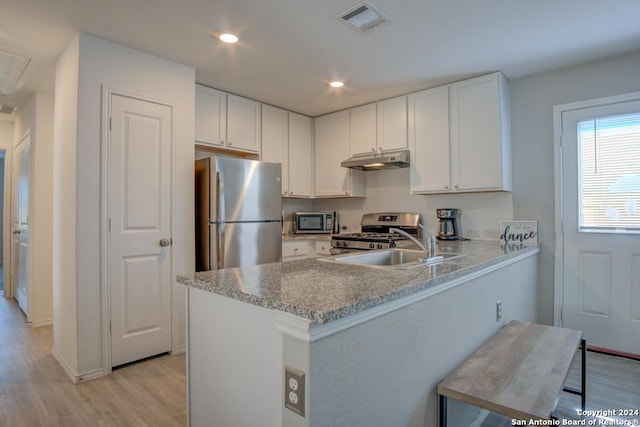 kitchen with sink, kitchen peninsula, light hardwood / wood-style flooring, white cabinetry, and appliances with stainless steel finishes