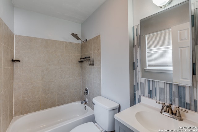 full bathroom featuring vanity, tiled shower / bath combo, and toilet