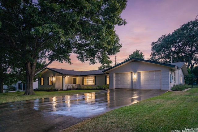 ranch-style home with a yard and a garage