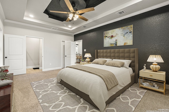 bedroom featuring crown molding, carpet, a tray ceiling, and ceiling fan