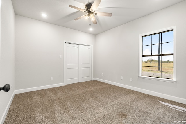 unfurnished bedroom featuring a closet, carpet, and ceiling fan