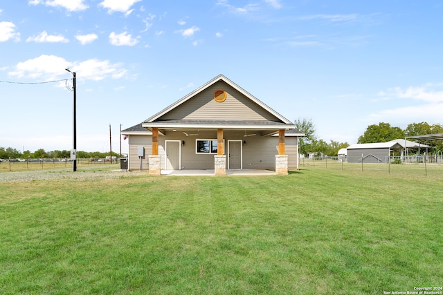 rear view of house featuring a lawn and a patio