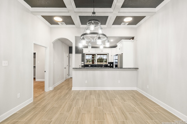 kitchen with light wood-type flooring, white cabinets, kitchen peninsula, coffered ceiling, and decorative light fixtures