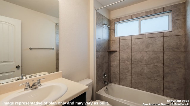 full bathroom with tiled shower / bath combo, vanity, and toilet