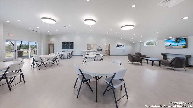 dining area with light wood-type flooring and lofted ceiling