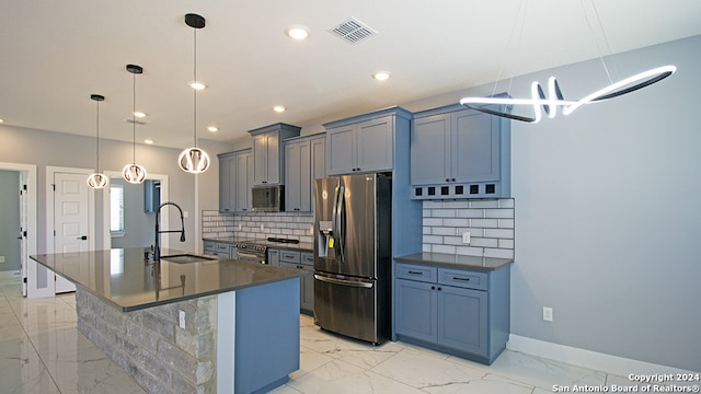 kitchen featuring decorative backsplash, an island with sink, hanging light fixtures, stainless steel appliances, and sink